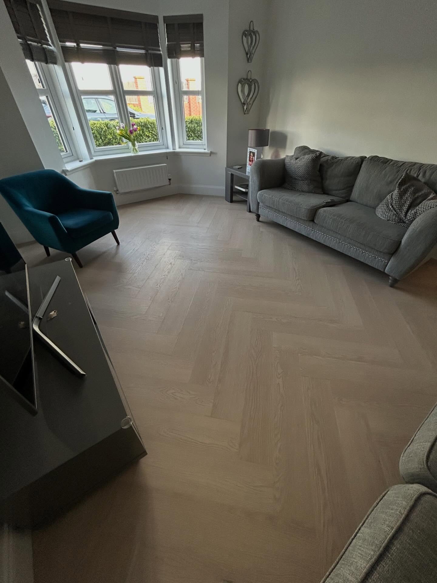 Continuous herringbone flooring installation across multiple rooms